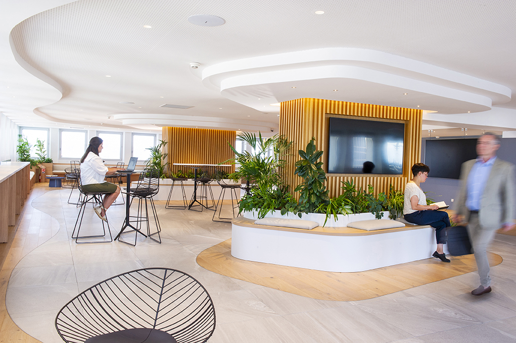 des professionnels traversent un open space avec des aménagements végétalisés - lieu d'accueil dans une grande banque française